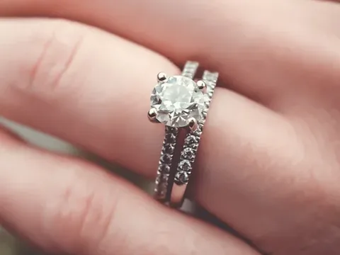 A diamond solitaire and a matching diamond band worn together on a hand