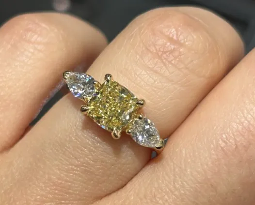 Yellow cushion cut diamond ring on hand