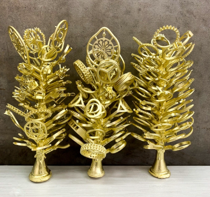 Three gold-coloured casting trees with jewellery pieces still attached to their central stems