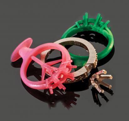 Pink and green ring patterns beside unfinished metal ring components