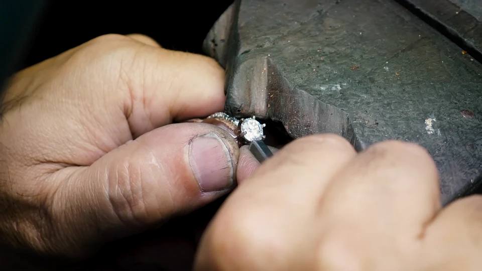 A jeweller refining a ring setting by hand at the workshop