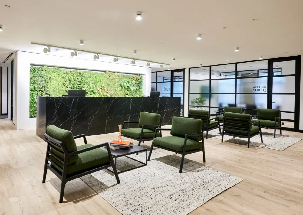 Collins Street reception and waiting area with green armchairs and a planted wall