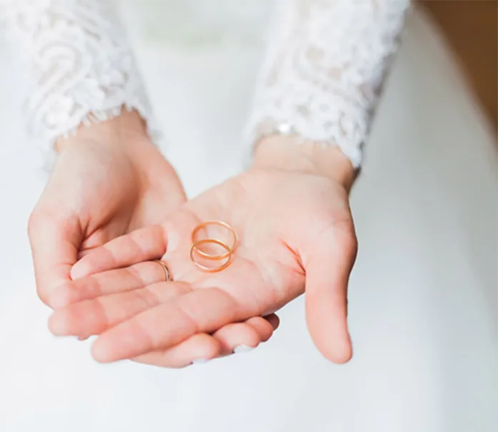 Cupped hands holding two wedding bands