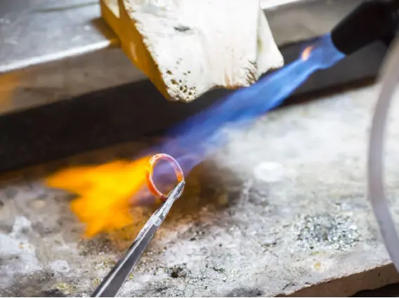 Goldsmith heating jewellery metal