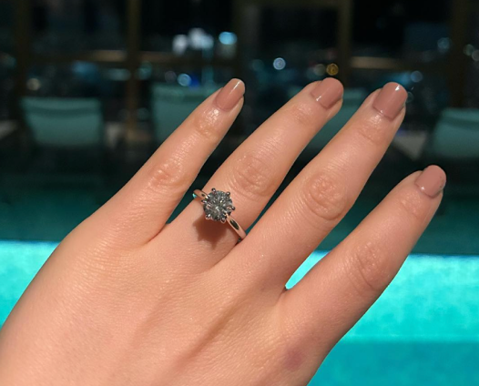 Round diamond engagement ring on hand