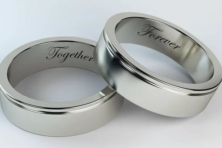 Two wedding bands engraved inside with the words Together and Forever.